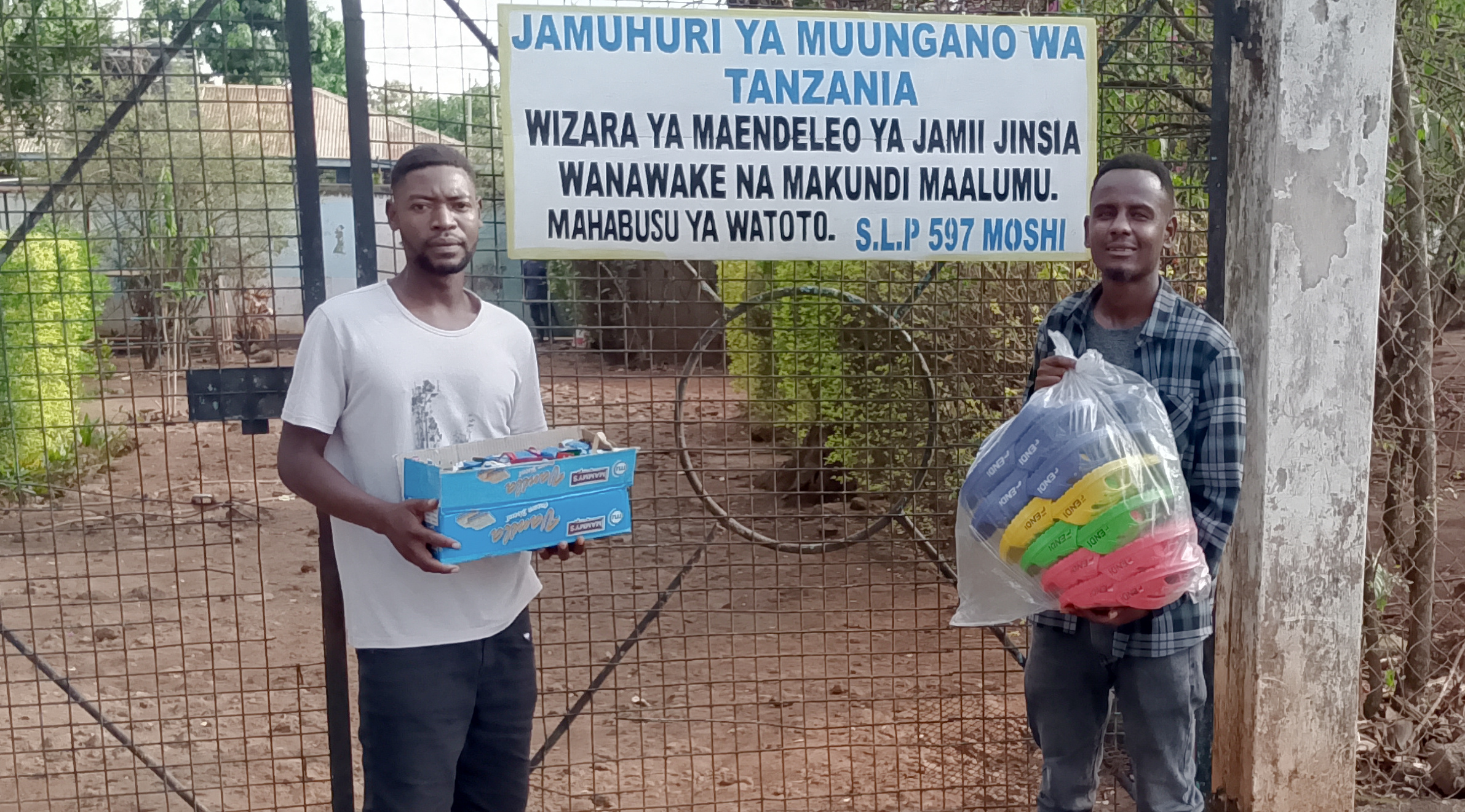 TOA College students Innocent and Samweli carrying Christmas gifts for the Juvenile Detention Center in Moshi Tanzania
